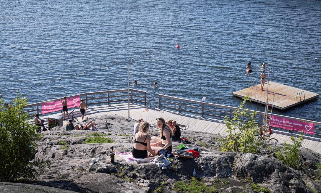 Suecos desfrutam de um dia ensolarado em meio ao surto de coronavírus, em Estocolmo Foto: NAINA HELEN JAMA / AFP/31-07-2020