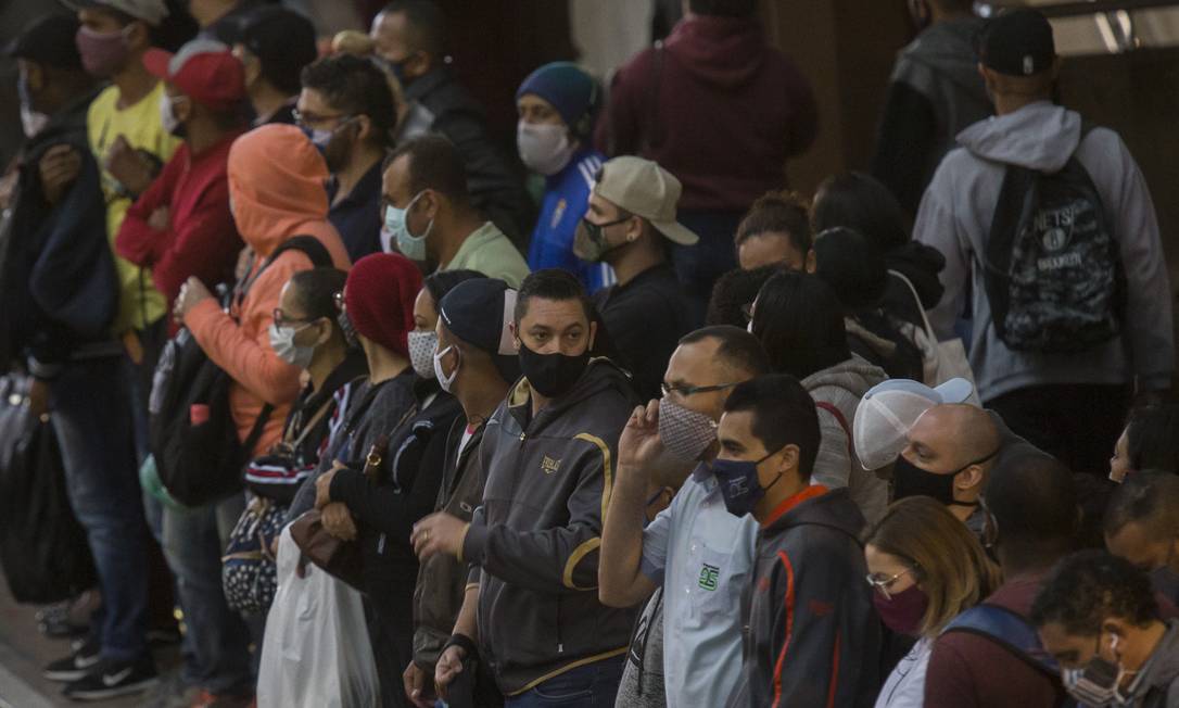 Em São Paulo, pessoas usam máscaras enquanto aguardam por chegada do trem para ir ao trabalho. Foto: Edilson Dantas / Agência O Globo