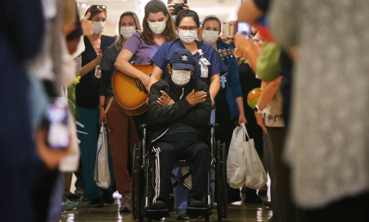 Paciente de 59 anos é acompanhando por profissionais de saúde ao receber por alta em hospital de Coronado, na California Foto: Mario Tama / Getty Images 08.05.2020