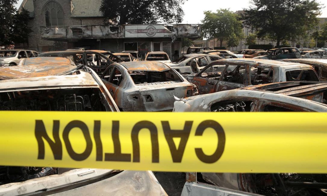 Veículos queimados por manifestantes em um estacionamento de carros usados são vistos na manhã desta segunda-feira, após noite de protesto em Kenosha Foto: SCOTT OLSON / AFP
