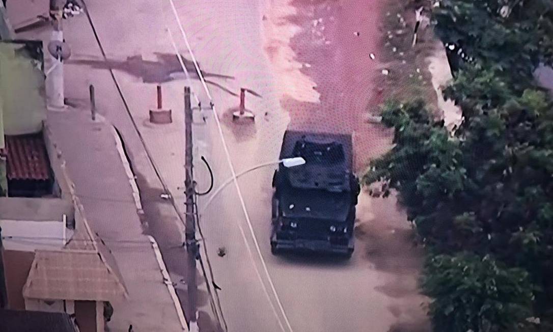 Um blindado da PM passa por uma barricada Foto: TV Globo / Reprodiução