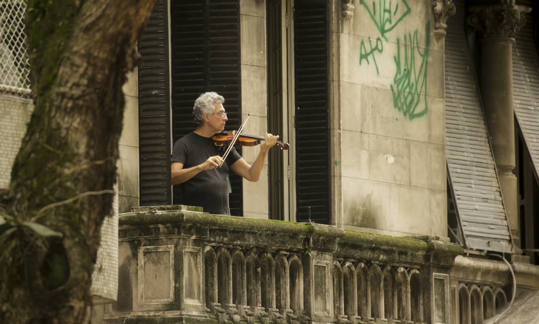 Música que vem das janelas. No auge do isolamento social, homem toca violino na sacada de seu apartamento na Avenida Oswaldo Cruz, no Flamengo, Zona Sul do Rio Foto: Gabriel de Paiva / Agência O Globo - 09/04/2020