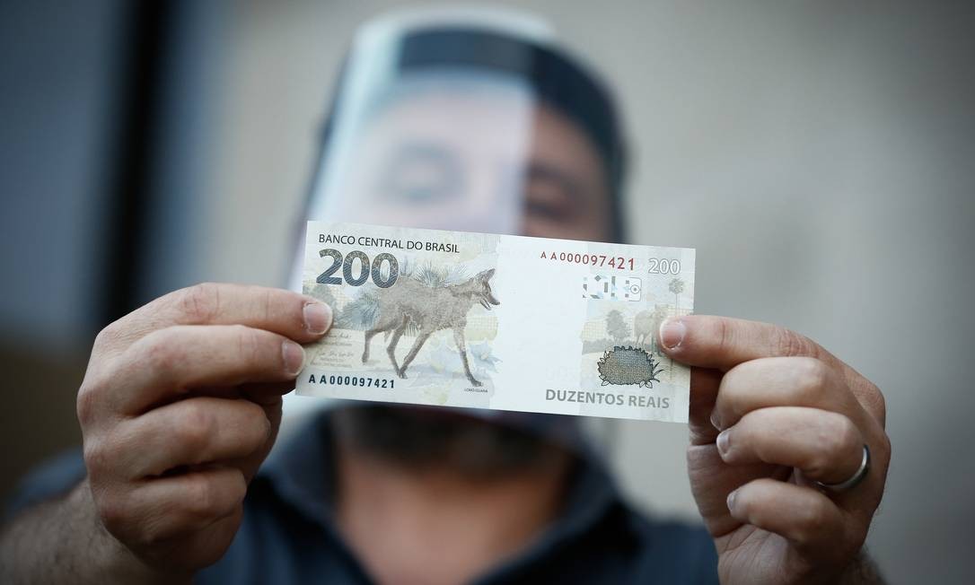 O colecionador Athos Camargo segura uma nota de R$ 200 em frente ao Banco Central, em Brasília. Nova nota, com logo-guará como símbolo da fauna brasileira, foi apresentada nesta quarta-feira e já está em circulação Foto: Pablo Jacob / Agência O Globo