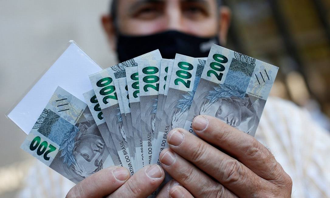 Homem com novas notas de R$ 200: medidas contra fraudes no auxílio. Foto: ADRIANO MACHADO / REUTERS