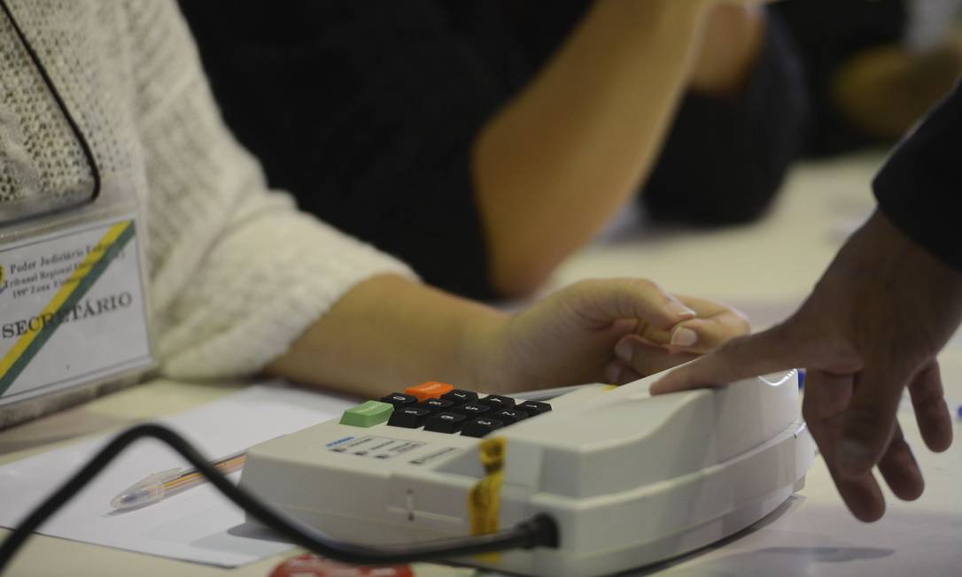 Em Niterói, eleitores usam cadastro biométrico antes de votar Foto: Agência O Globo