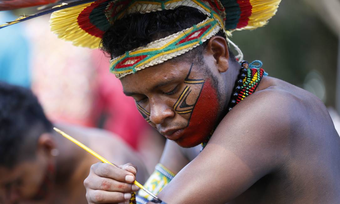 Imagem ilustrativa de indígena fazendo pintura corporal Foto: Michel Filho / Agência O Globo