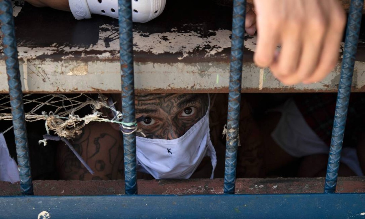 Membro da gangue Bairro 18 observa de uma cela superlotada do presídio de Quezaltepeque Foto: YURI CORTEZ / AFP