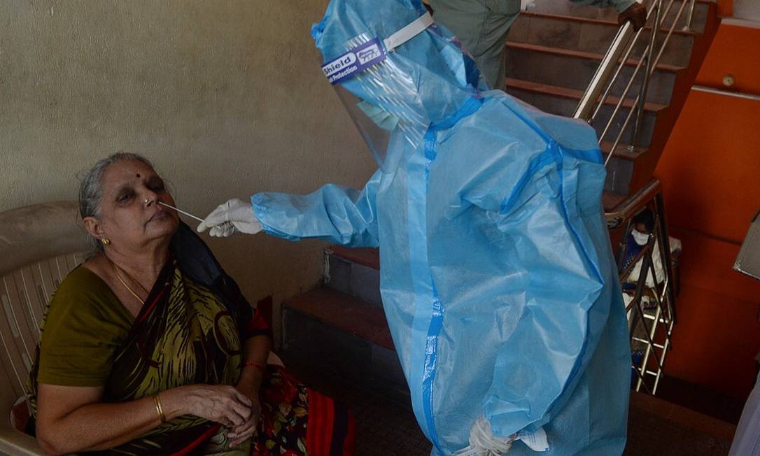 Trabalhador da saúde realiza teste de Covid-19 em moradora de Chennai Foto: ARUN SANKAR / AFP 