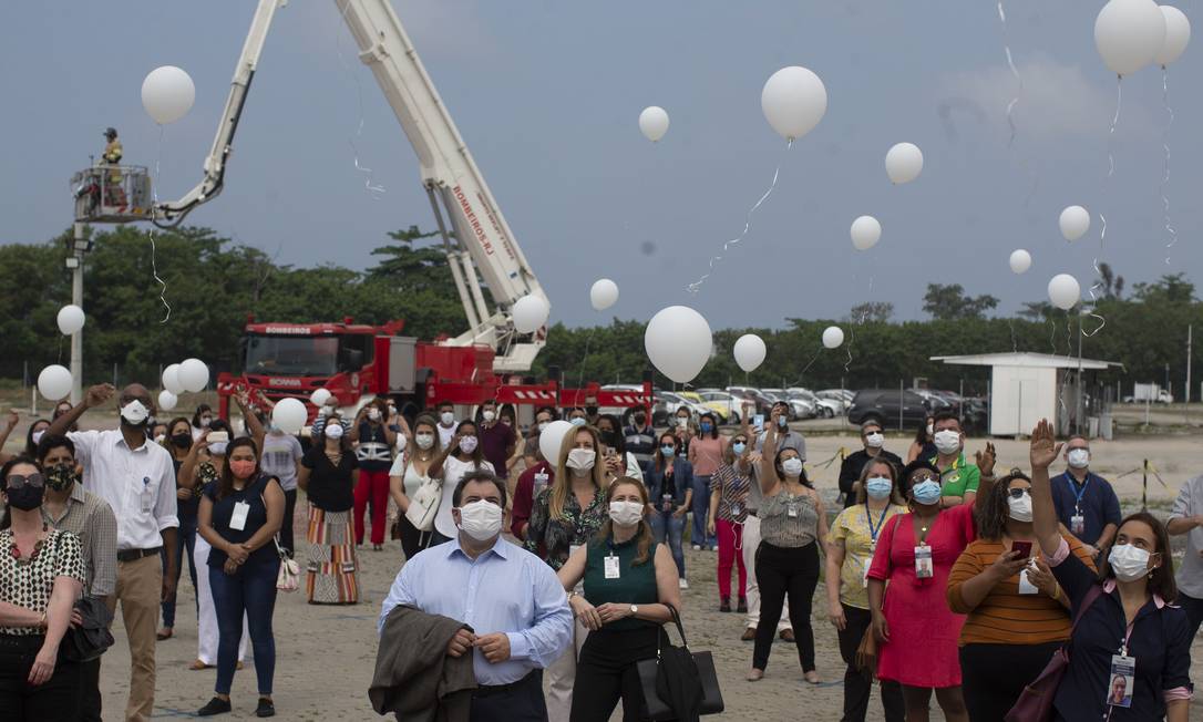 Músico dos bombeiros toca sax e funcionários soltam balões brancos para homenagear vítimas da Covid Foto: Márcia Foletto / Agência O Globo