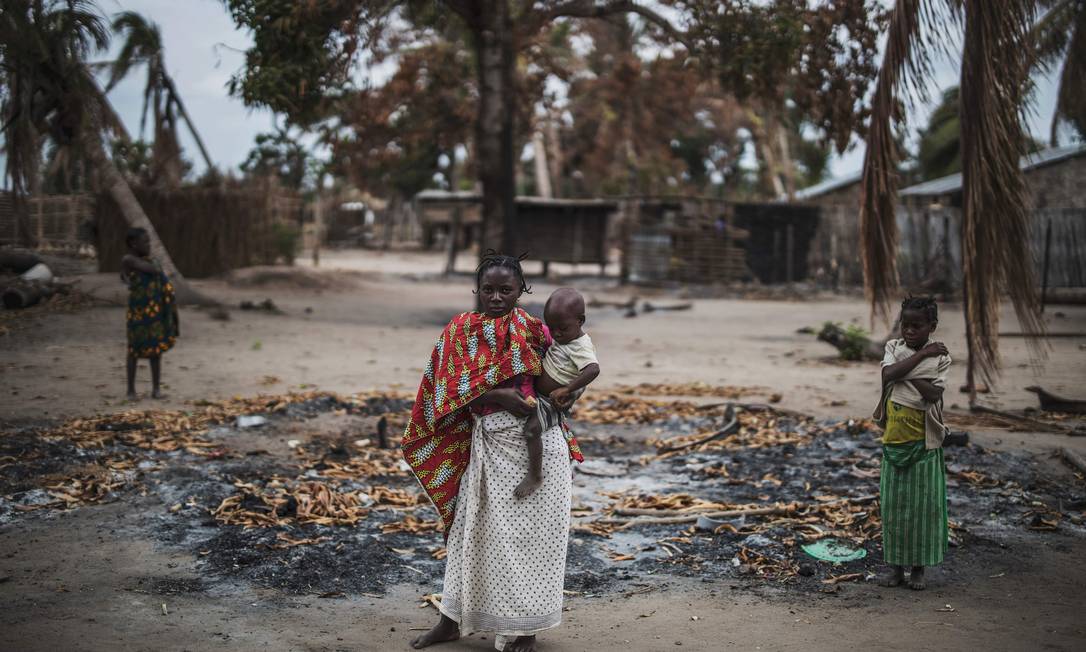 Mulher segura criança depois de ataque contra a aldeia onde ela morava, no Norte de Moçambique Foto: MARCO LONGARI / AFP