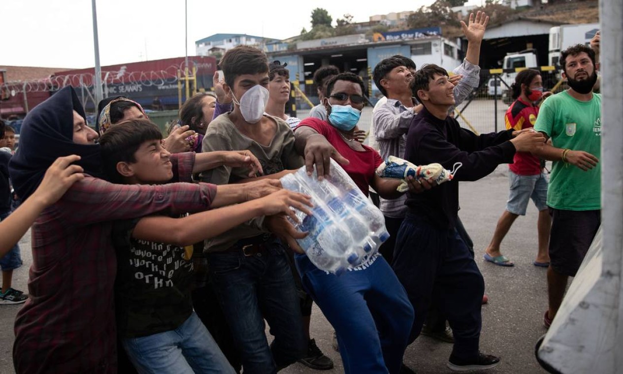 Setembro - Distribuição de água gerou tumulto entre os refugiados, que passaram a disputar as garrafas doadas por organização não governamental Foto: ALKIS KONSTANTINIDIS / REUTERS - 12/09/2020