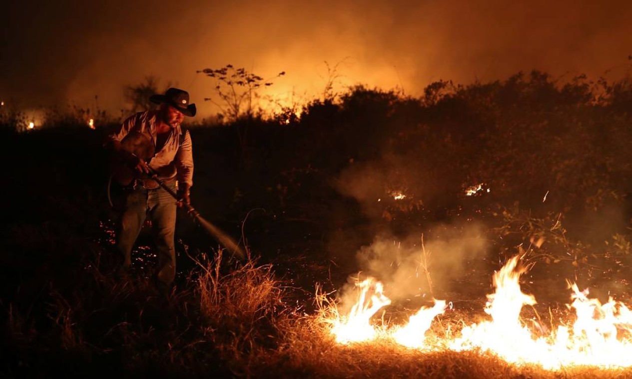 Funcionário de um fazenda tenta apagar um incêndio na propriedade em que trabalha no Pantanal, em Pocone, Mato Grosso Foto: AMANDA PEROBELLI / REUTERS - 26/008/2020