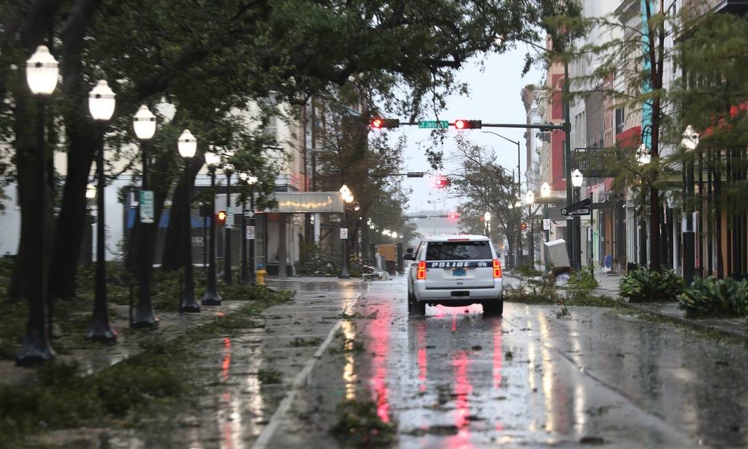 Viatura policial passa por uma rua repleta de galhos quando ventos e chuva causados ​​pelo furacão Sally atingem a cidade de Mobile, Alabama Foto: JOE RAEDLE / AFP