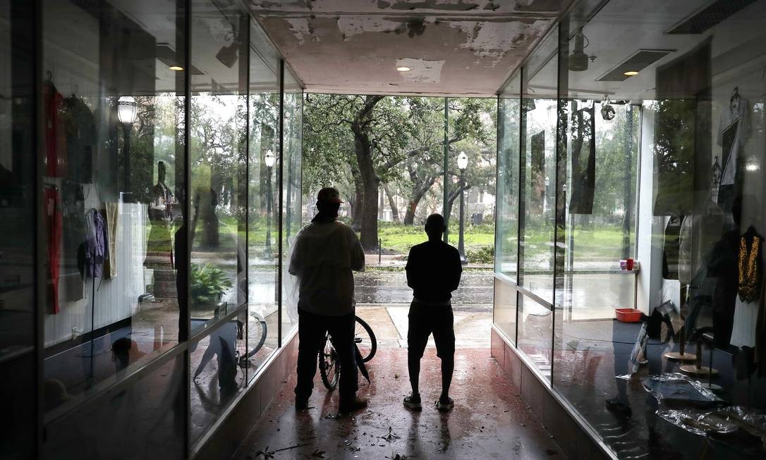 As pessoas se abrigam em uma galeria enquanto os ventos e a chuva do furacão Sally atingem Mobile, Alabama.  Foto: JOE RAEDLE / AFP