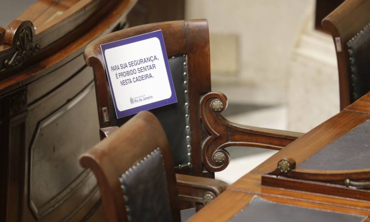 Cartazes foram colocados em algumas cadeiras para garantir distanciamento social entre vereadores que preferiram acompanhar a sessão presencialmente Foto: Antonio Scorza / Agência O Globo