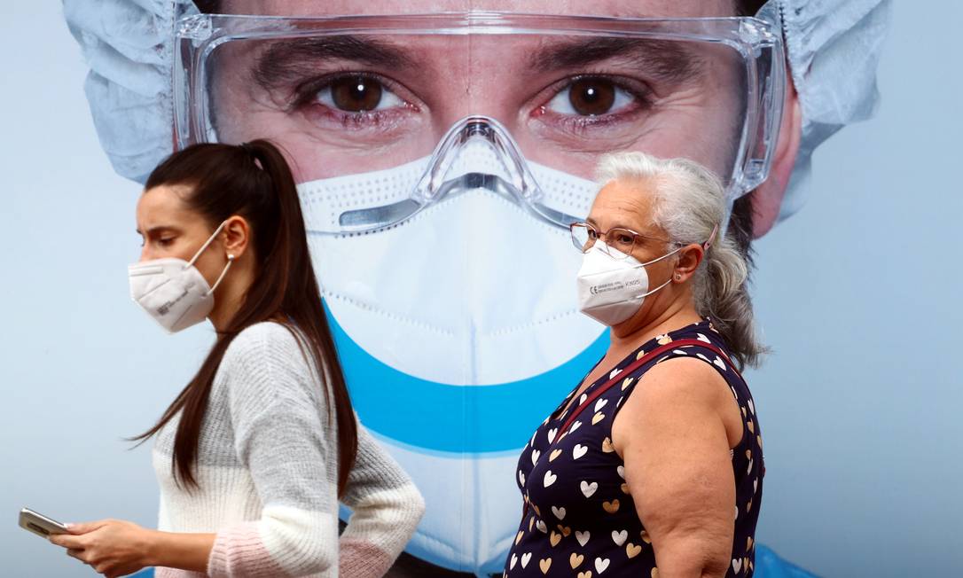 Duas mulheres caminham em Madri utilizando máscara Foto: Sergio Perez / Reuters