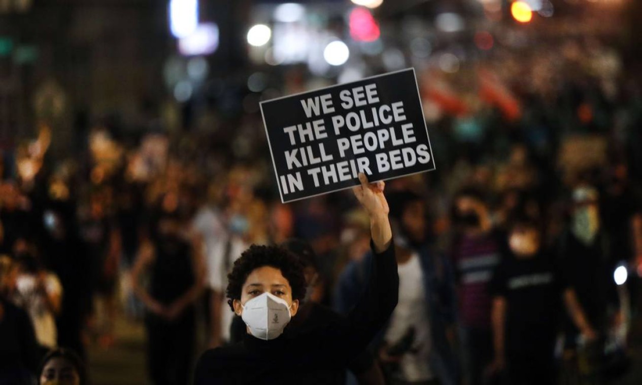 "Nós vemos policias matando pessoas nas camas delas", diz a placa de manifestante no Brooklyn, em Nova Iorque Foto: SPENCER PLATT / AFP
