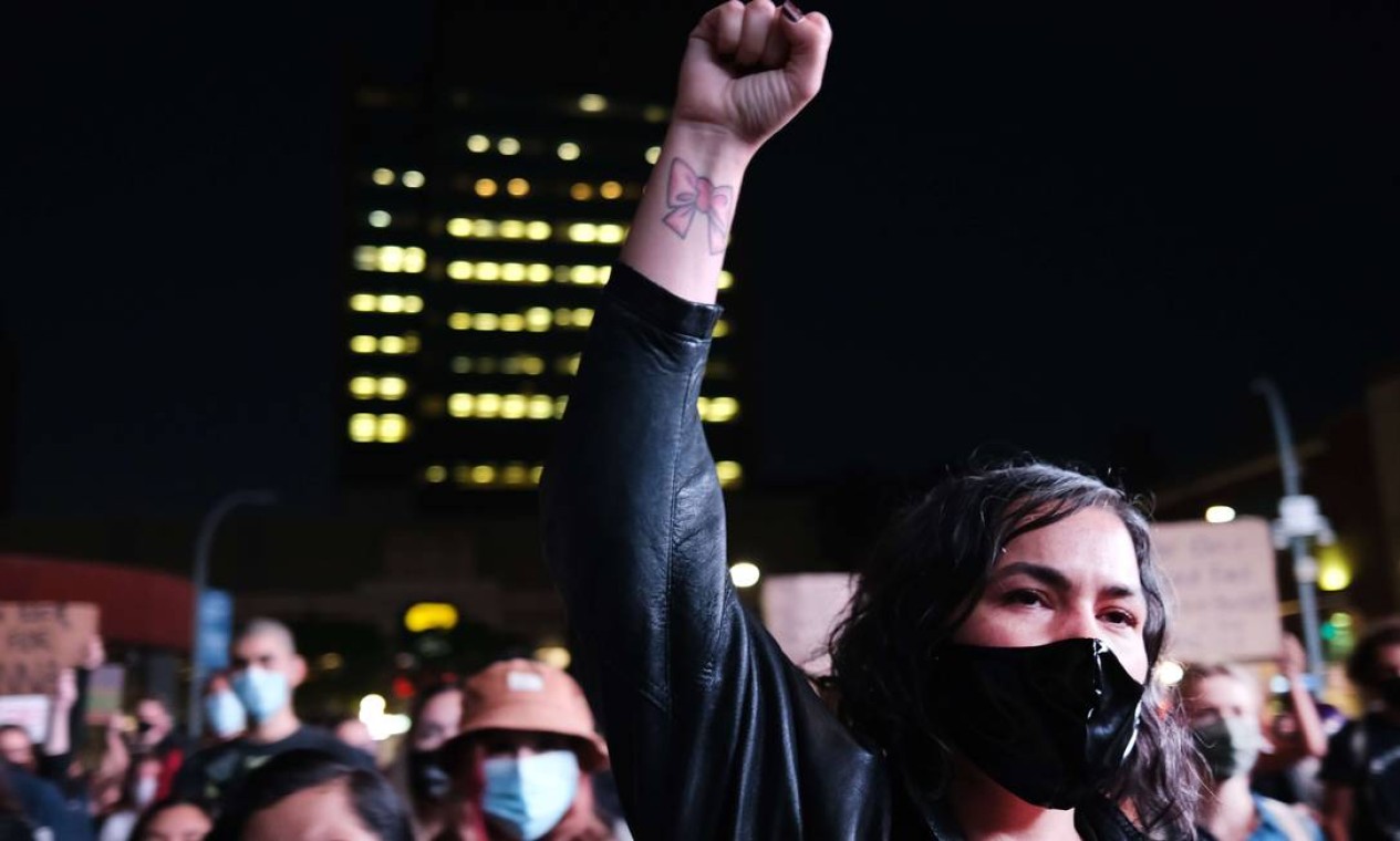 Manifestante usando máscara de proteção ergue punho cerrado, gesto símbolo da luta racial, no Brooklyn, em Nova Iorque Foto: SPENCER PLATT / AFP