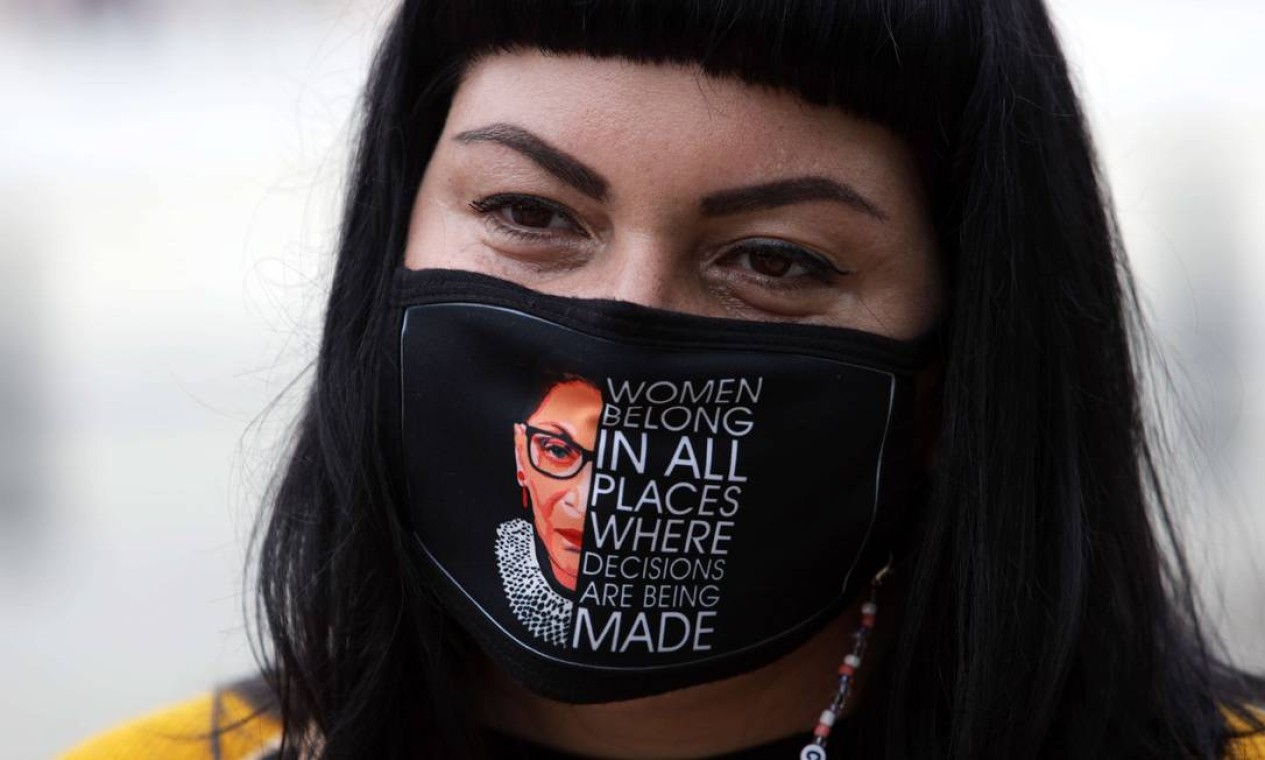 Mulher usa máscara com rosto da juíza Ruth Bader Ginsburg durante homenagens na Suprema Corte Foto: ALEX WONG / AFP
