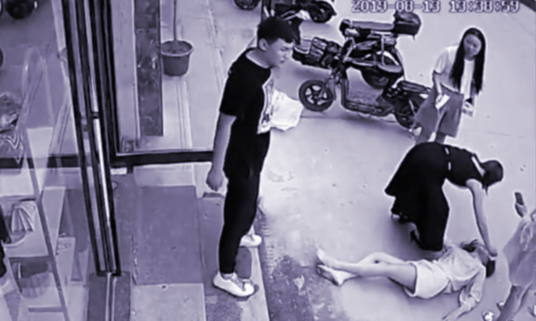 Liu na rua depois de saltar de uma janela para fugir da violência do marido. A violência doméstica só recentemente como a ser vista como um problema na China Foto: NYT