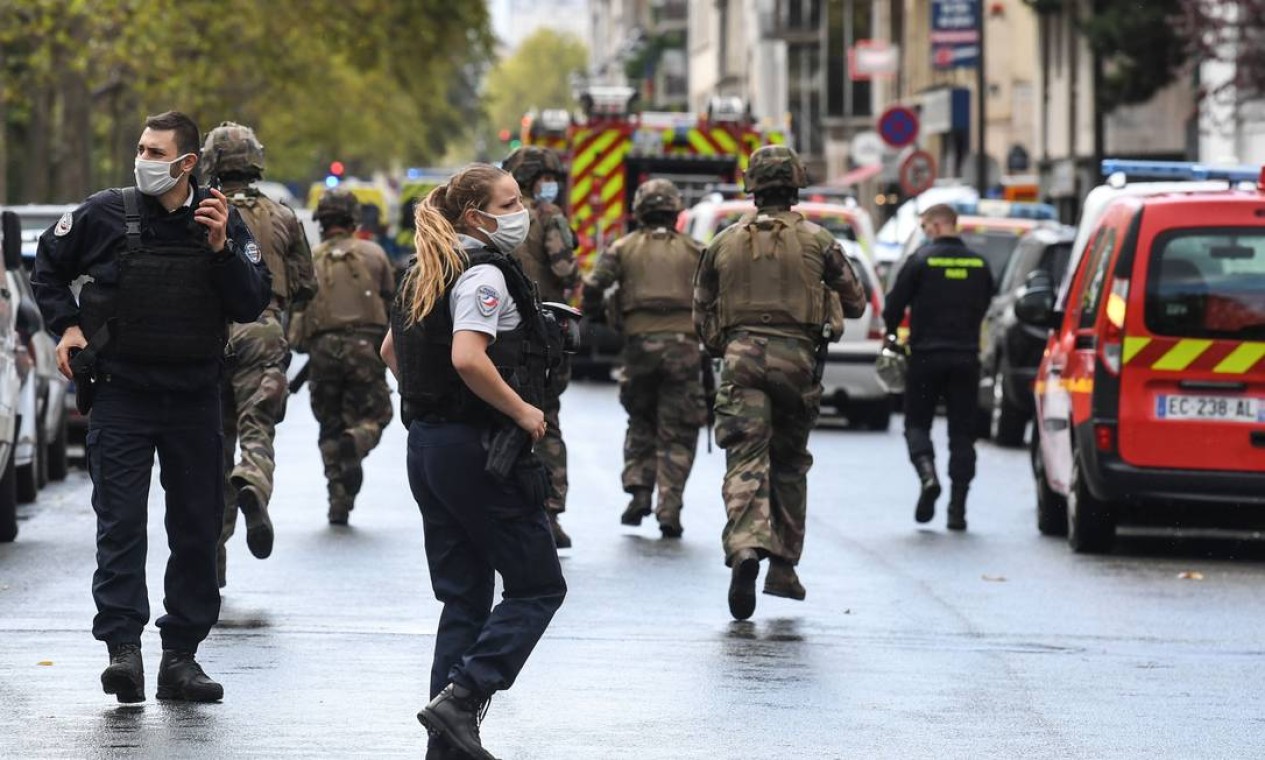 Soldados do Exército francês correm para o local onde duas pessoas foram feridas a facadas, perto dos antigos escritórios do jornal satírico Charlie Hebdo, em Paris Foto: ALAIN JOCARD / AFP