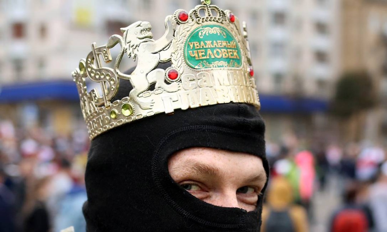 Manifestante usa uma coroa coroa de plástico para criticar a posse de Lukashenko, realizada a portas fechadas e com poucos convidados no dia 23 Foto: - / AFP