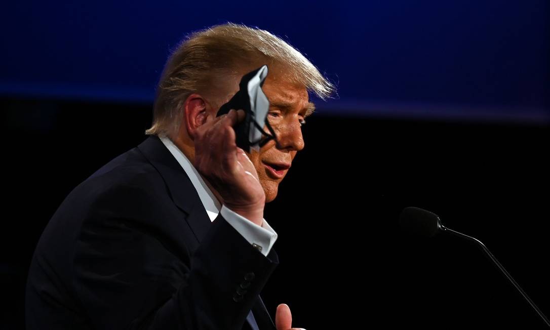 US President Donald Trump holds up a mask while speaking during the first presidential debate in Cleveland, Ohio.  Trump announced on Friday that he and first lady Melania tested positive for the new coronavirus Photo: JIM WATSON / AFP