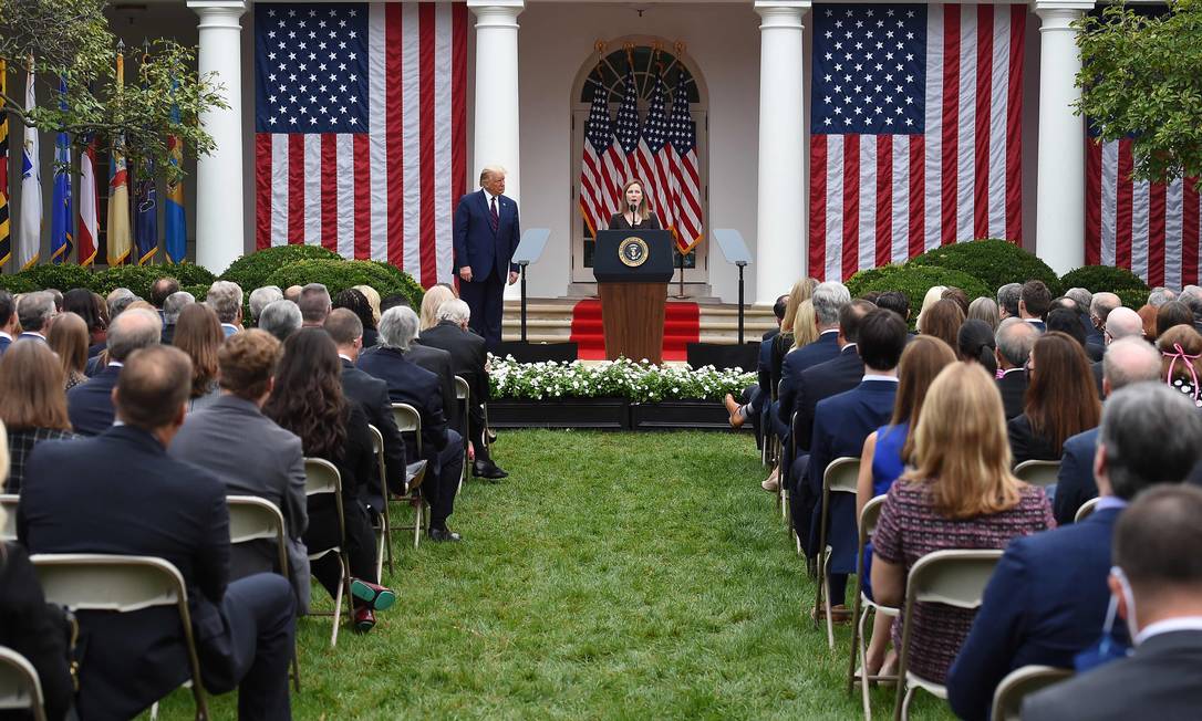 Indicada para a Suprema Corte dos EUA pelo presidente Donald Trump, Amy Coney Barrett discursa em cerimônia que reuniu 200 pessoas nos jardins da Casa Branca, muitas sem máscaras e longe de respeitar o distanciamento social Foto: OLIVIER DOULIERY / AFP