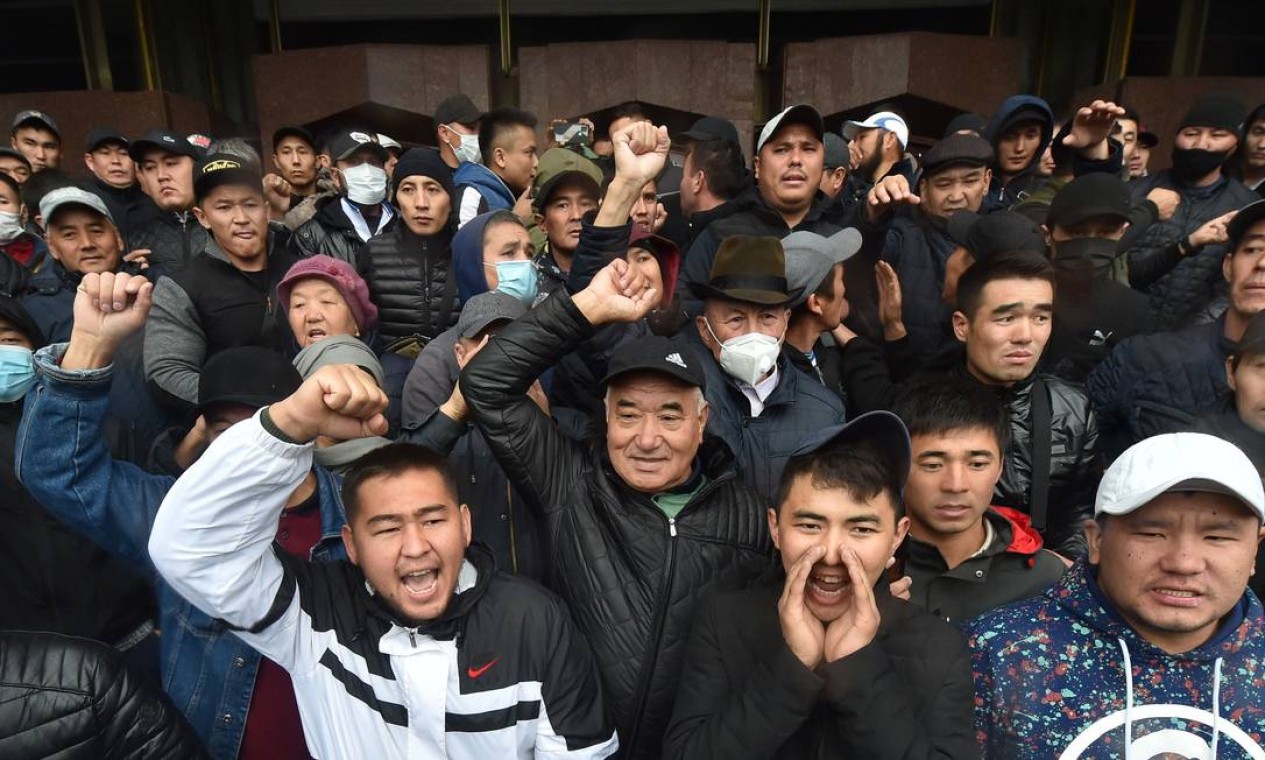 Pessoas protestam contra os resultados de uma eleição parlamentar, em frente à sede do governo que foi tomada em Bisqueque, Quirguistão Foto: VYACHESLAV OSELEDKO / AFP