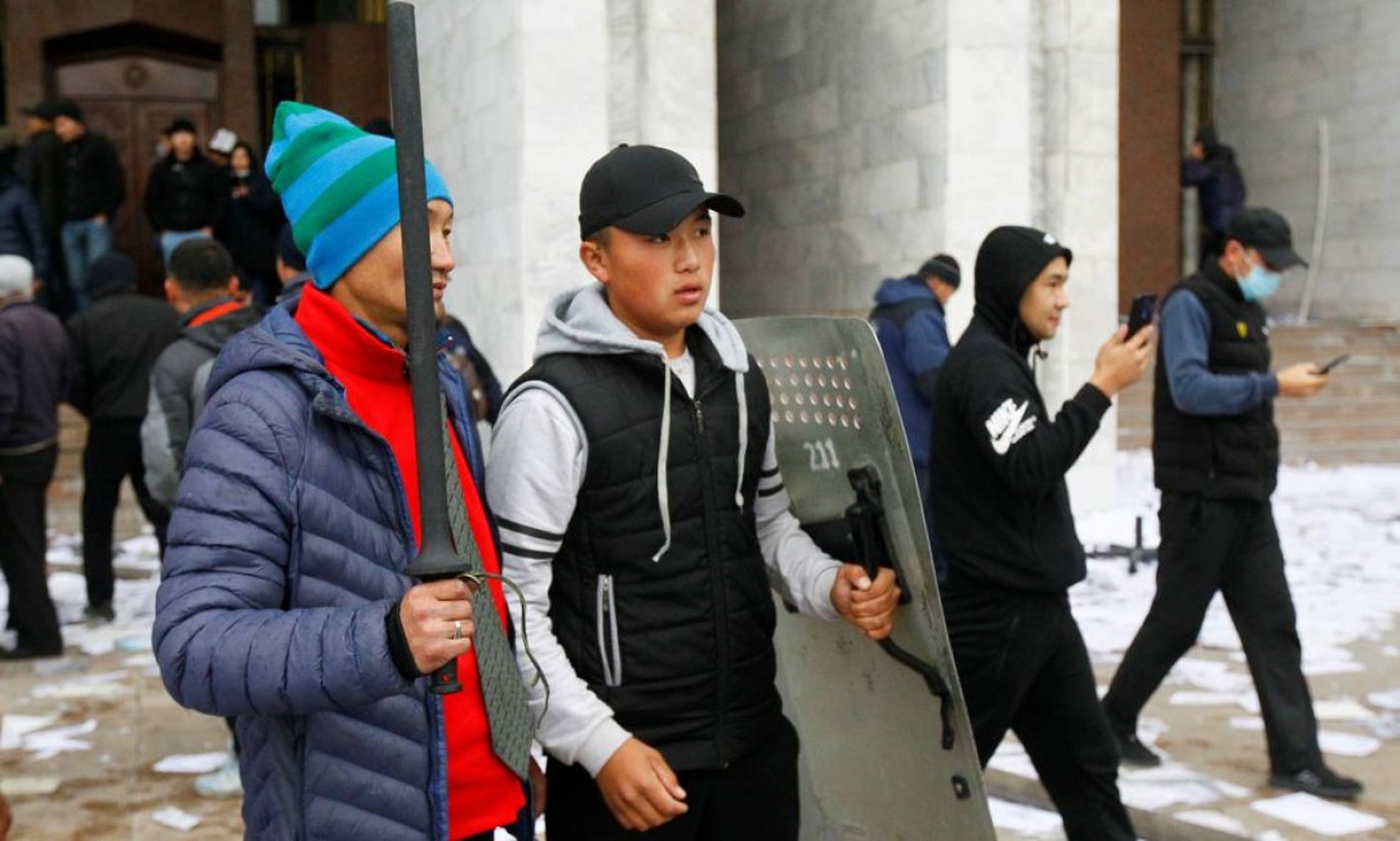 Manifestantes caminham com arma branca e escudo em Bisqueque Foto: VLADIMIR PIROGOV / REUTERS