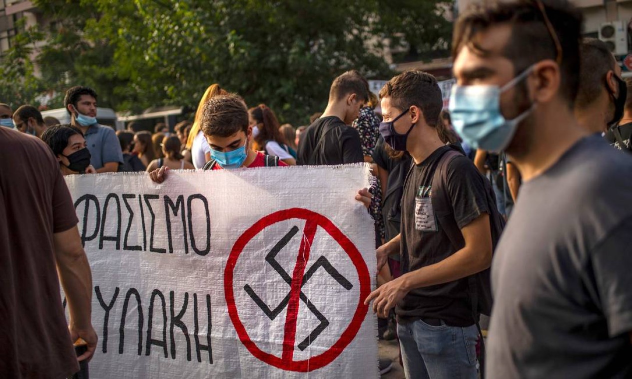 Manifestantes carregam cartaz antinazista, durante protesto na capital grega, Atenas Foto: ANGELOS TZORTZINIS / AFP