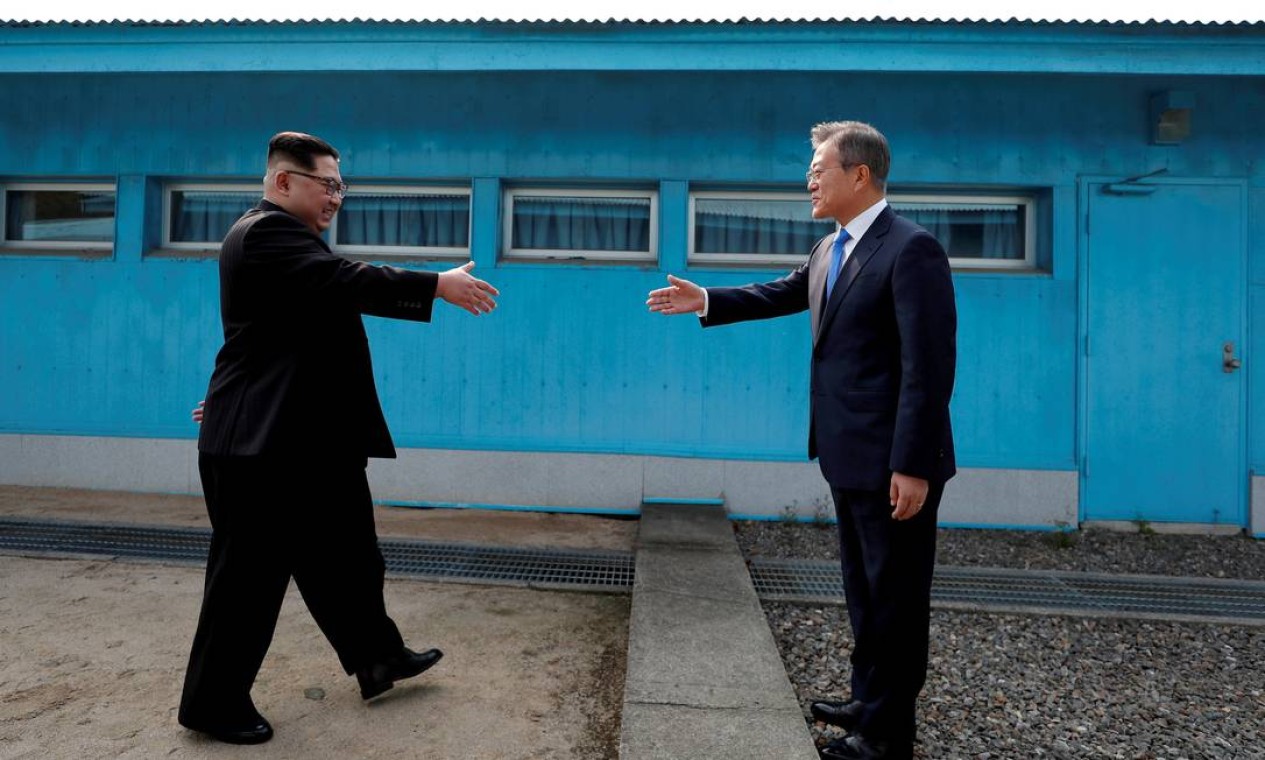 O presidente sul-coreano, Moon Jae-in, e o líder norte-coreano, Kim Jong-un, apertam as mãos no vilarejo de trégua de Panmunjom, dentro da zona desmilitarizada que separa as duas Coreias Foto: Reuters - 21/04/2018