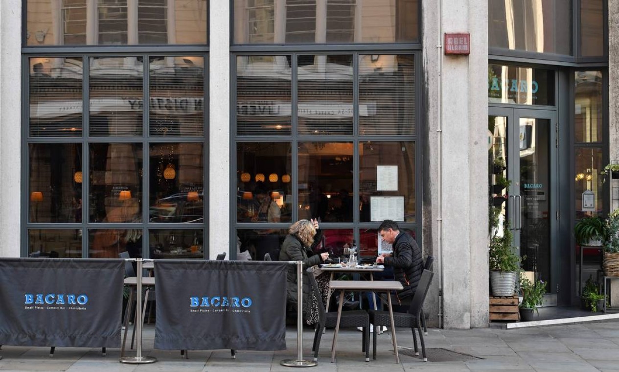 Os clientes se sentam em uma mesa do lado de fora de um restaurante em Liverpool. Cidade registrou 600 casos de Covid-19 para cada cem mil habitantes na semana passada Foto: PAUL ELLIS / AFP