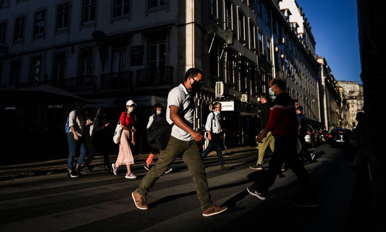 Pessoas com máscara facial caminham por Lisboa. Nível de alerta em todo o país foi elevado com um decreto de estado de calamidade, último nível antes do estado de alerta Foto: PATRICIA DE MELO MOREIRA / AFP - 12/10/2020