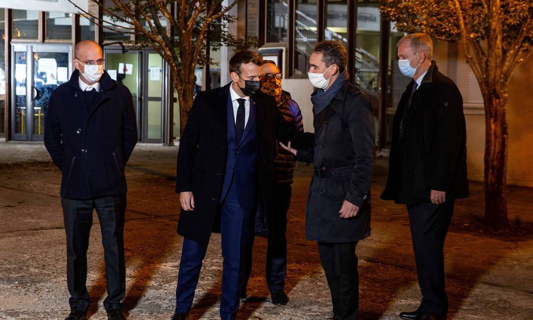 Macron (ao centro) visita o local em que o professor foi atacado com faca Foto: POOL / REUTERS