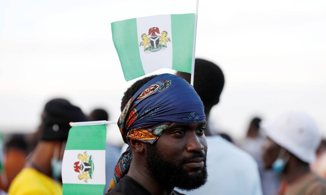 Manifestante decora seu lenço com a bandeira da Nigéria durante um protesto contra a suposta brutalidade policial em Lagos Foto: TEMILADE ADELAJA / REUTERS