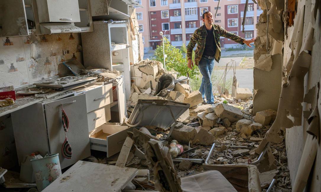 Homem verifica apartamento de seu vizinho danificado durante conflito na região separatista de Nagorno-Karabakh, na cidade de Terter Foto: BULENT KILIC / AFP/18-10-2020
