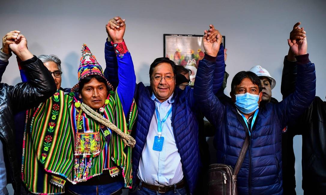 É citado pelas urnas como o presidente eleito da Bolívia, Luis Arce (centro), 57, comemora vitória em La Paz no primeiro turno das eleições presidenciais de domingo. Foto: RONALDO SCHEMIDT / AFP