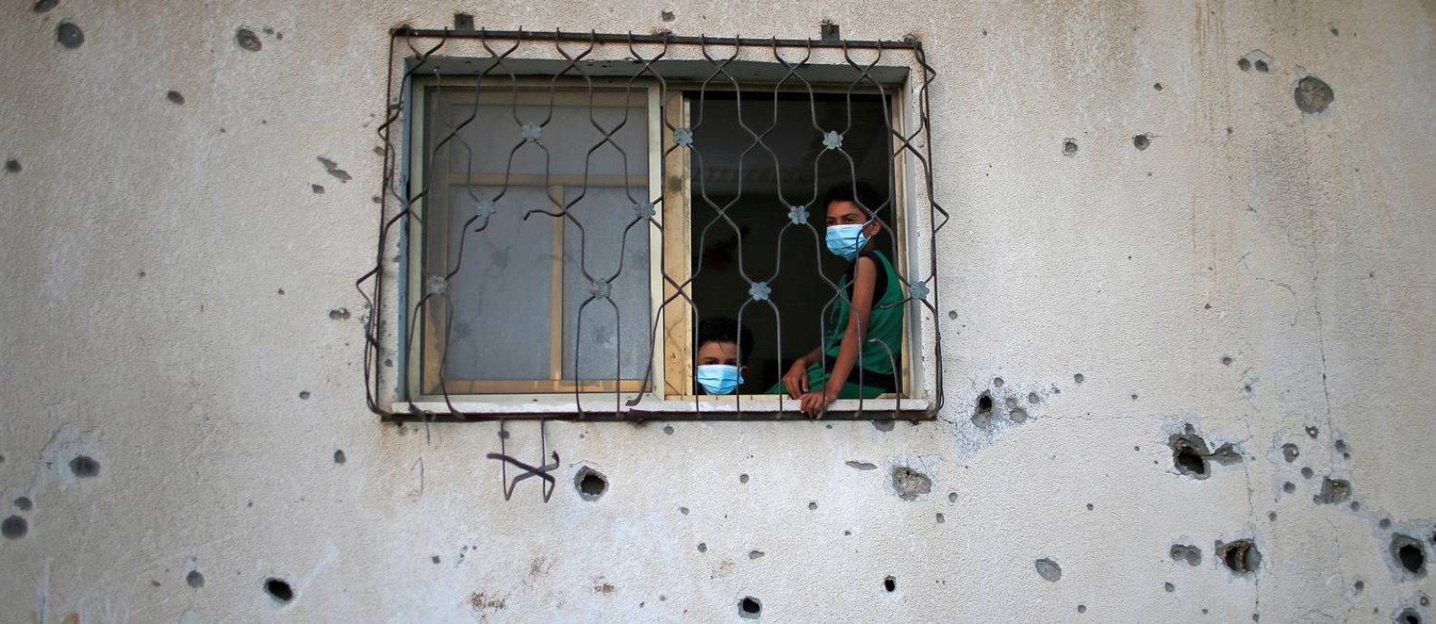 Crianças palestinas dentro de uma casa alvejada na Faixa de Gaza durante a pandemia da Covid-19 Foto: Suhaib Salem / Reuters