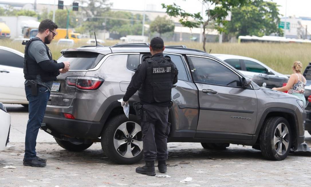 Peritos analisam o carro atingido por tiros na Cidade Alta Foto: Fabiano Rocha / Agência O Globo