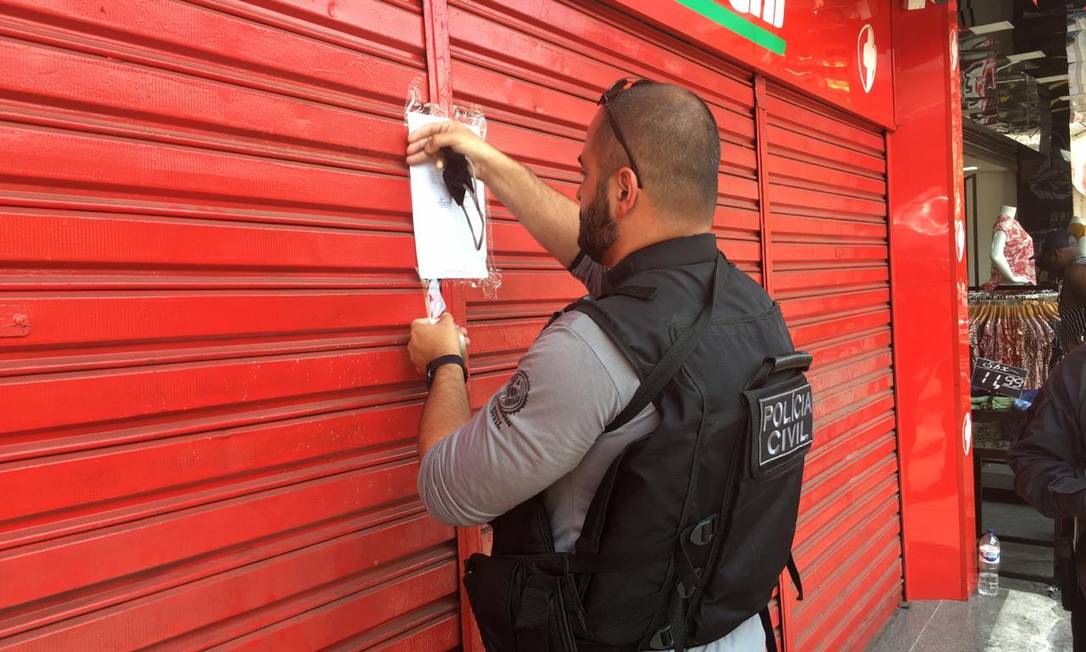 Agente interdita farmácia em Madureira durante operação contra a lavagem de dinheiro da milícia Foto: Rafael Nascimento de Souza / Agência O Globo