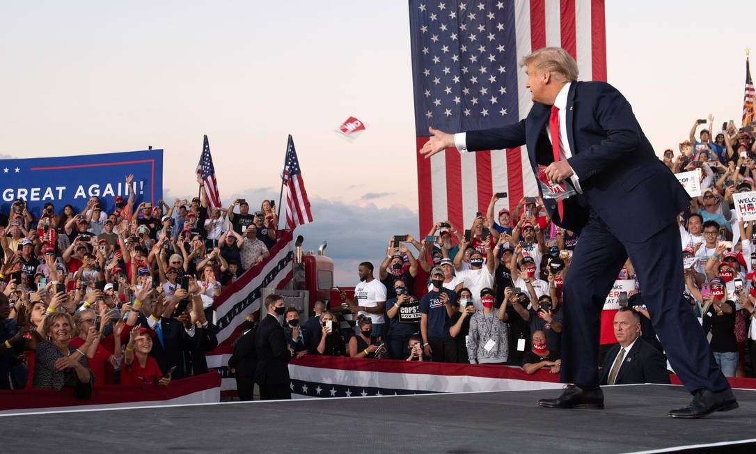Em retomada da campanha após se curar da Covid-19, Donald Trump joga máscaras para apoiadores durante comício em Sanford, na Flórida Foto: Saul Loeb / AFP - 12/10/2020