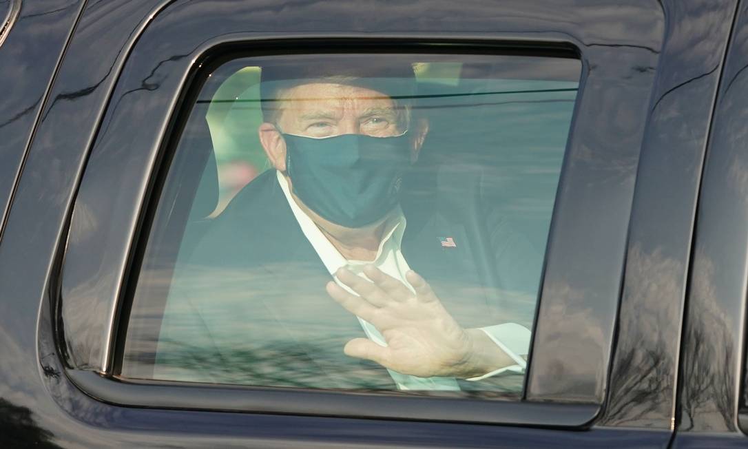 Trump acena para apoiadores, ao fazer um passeio de carro no entorno do hospital
onde está internado com Covid-19, em outubro de 2020 Foto: Alex Edelman / AFP - 04/10/2020