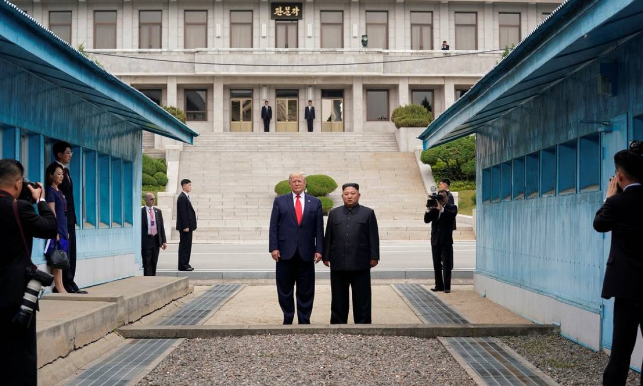 Donald Trump caminha para o lado norte da Linha de Demarcação Militar que divide as Coréias do Norte e do Sul acompanhado do líder norte-coreano, Kim Jong-un. Trump foi o primeiro presidente americano a entrar na Coreia do Norte, em junho do ano passado Foto: KEVIN LAMARQUE / Reuters - 30/06/2019