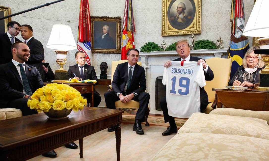 Trump entrega uma camisa personalizada, simbolizando o esporte nacional, ao Presidente Jair Bolsonaro durante reunião na Casa Branca em março de 2019 Foto: Isac Nóbrega / PR - 19/03/2019