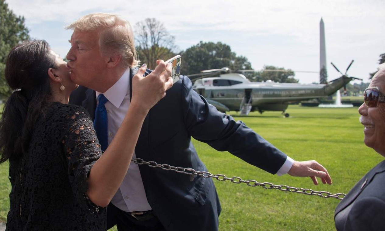 Trump beija uma mulher antes de partir do gramado sul da Casa Branca, em Washington Foto: JIM WATSON / AFP 02/10/2018