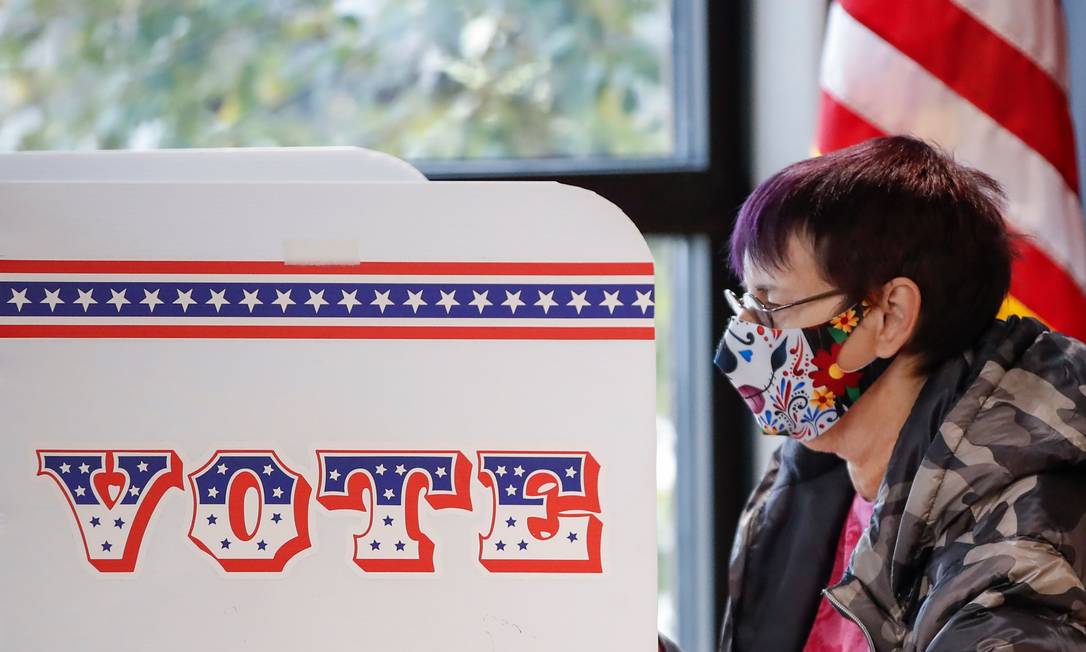 Eleitora vota antecipadamente em urna na cidade de Milwaukee, em Wisconsin Foto: KAMIL KRZACZYNSKI / AFP
