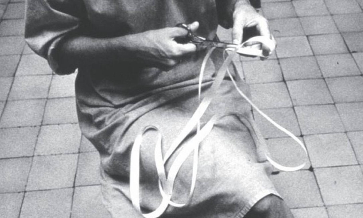 Lygia e a obra 'Caminhando' (1964), feita com tesoura e tira de papel Foto: Associação Cultural O Mundo de Lygia Clark