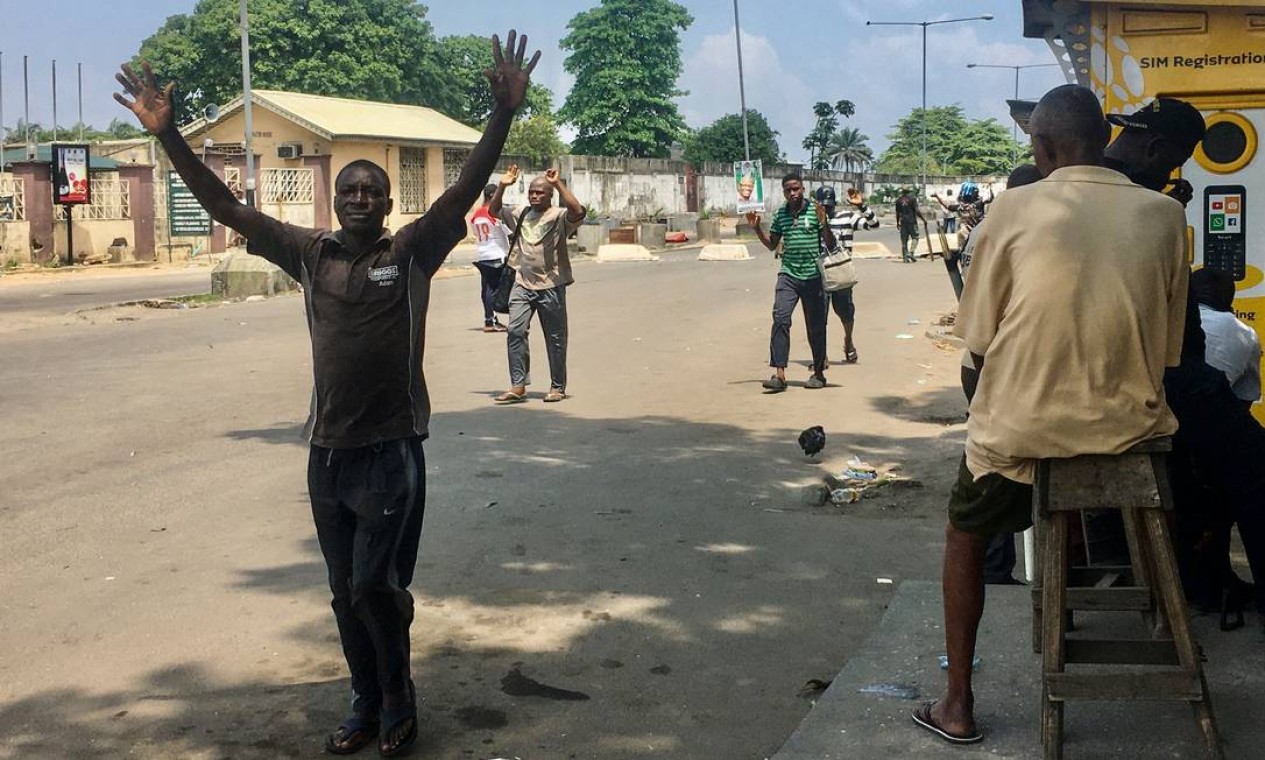 Policiais em Lagos, Nigéria, montaram postos de controle, onde os policiais carregavam facões e forçavam os residentes a passar pela área com os braços levantados.  Foto: Sophie Bouillon / AFP