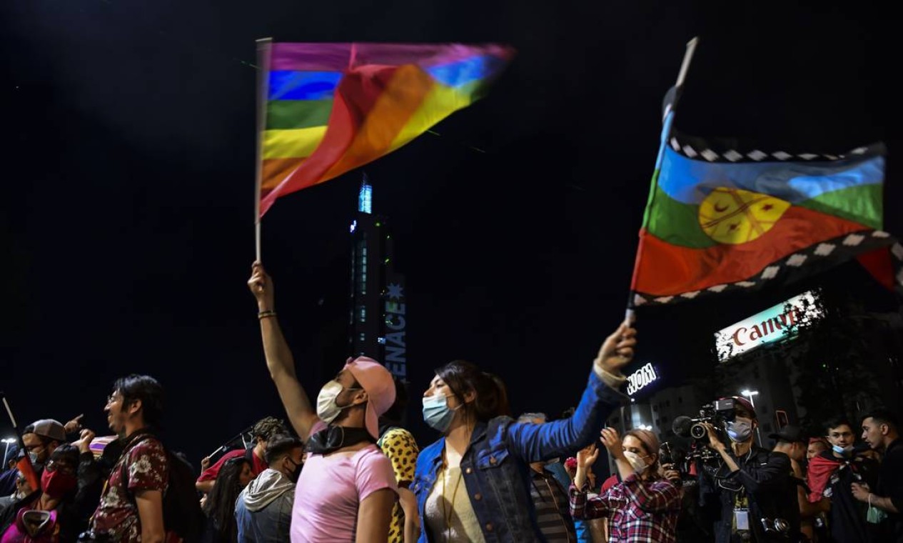 Manifestante segura bandeira arco-íris, que representa a diversidade sexual, na Plaza Italia, na capital Santiago Foto: MARTIN BERNETTI / AFP